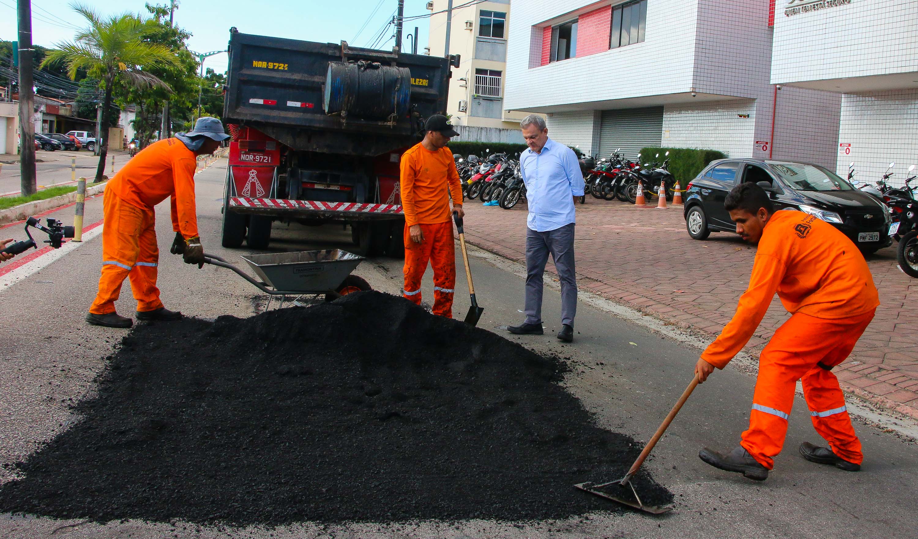 sarto observa operários trabalhando na operaração tapa-buracos